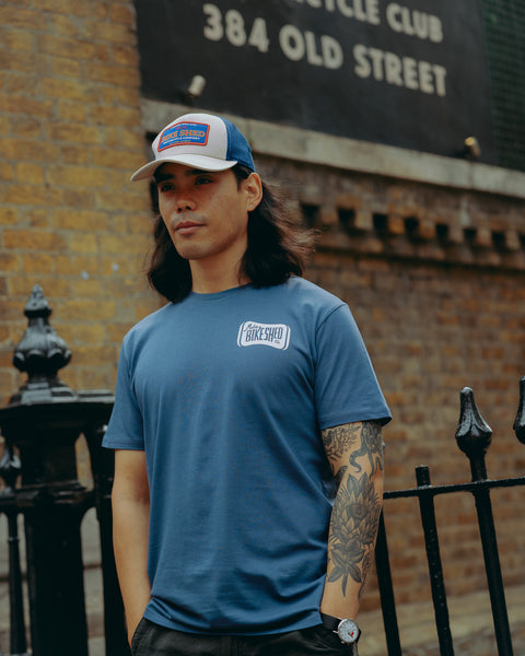 Model wearing Navy blue t-shirt with 'Moto Bikeshed co'  logo