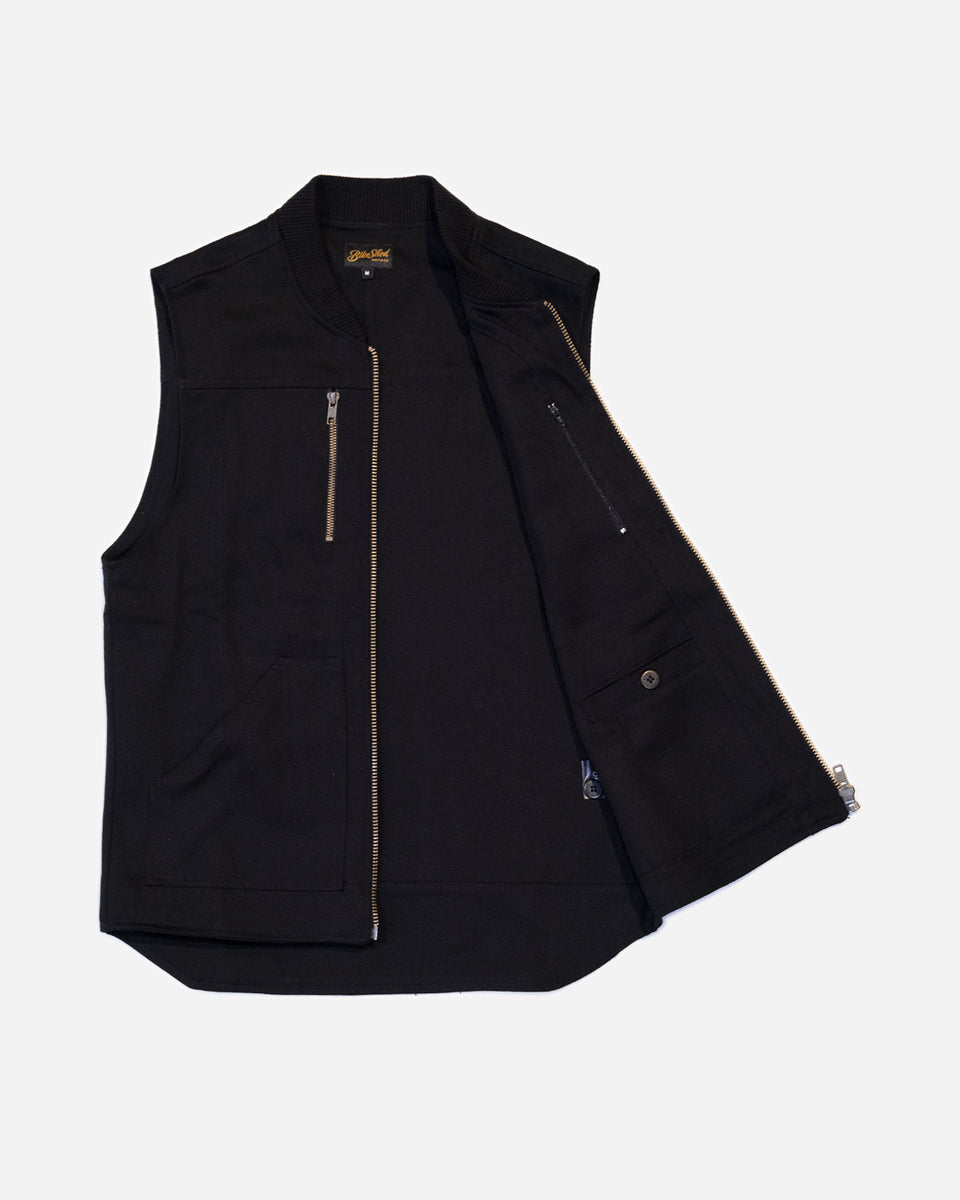 Black motorcycle vest with zippers on a white background